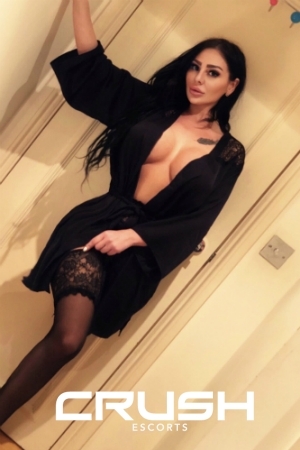 Angelina CIM escort is wearing a black robe and stockings.